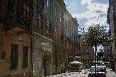 Lviv, Ukrayna-1 Haziran 2019: turistler Lviv kafeler ile büyüleyici sokak birinde yürüyüş. Renkli lens fişekleri ile güneş altında çekilen fotoğraf
