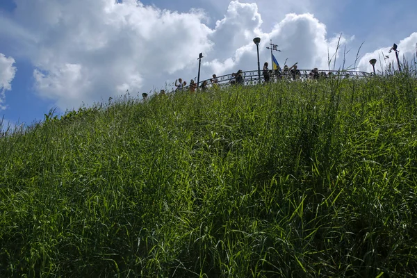 Lviv, Ucrania - 2 de junio de 2019: personas y bandera ondeando en la parte superior de la Unión de Lublin Mound. Se encuentra en la cumbre del Castillo de Lviv en Lviv — Foto de Stock