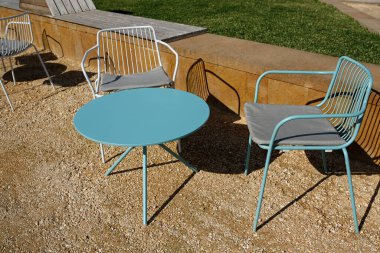 Güneşli bir günde açık restoran masası ve sandalyeler.