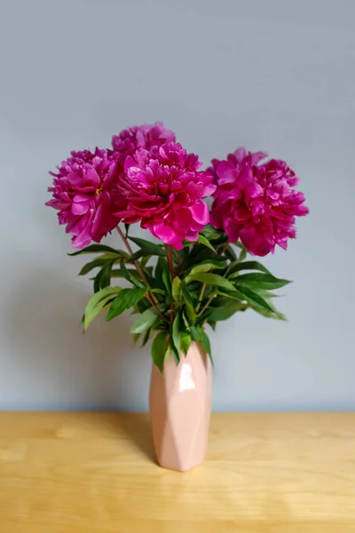 beautiful bouquet of peonies on wooden table