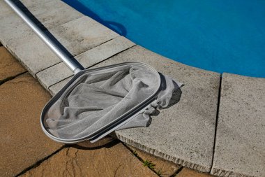 Mavi yüzme havuzunun yanında temizlik ağı 