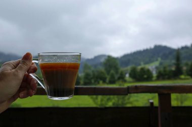 Dağdaki balkonda kahve bardağı var.