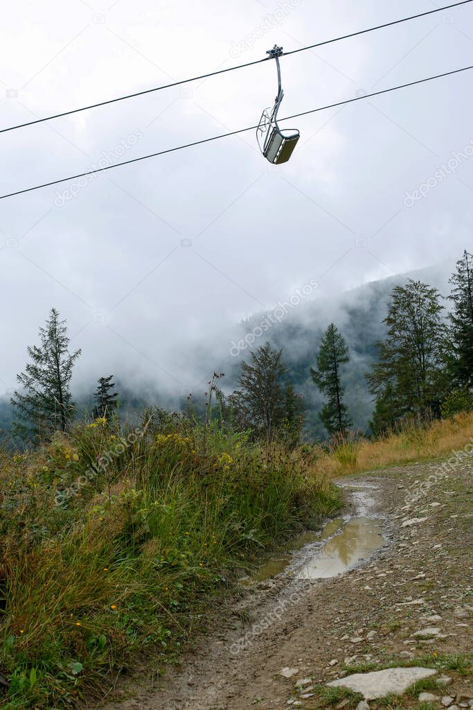 empty chairlift , cloudy and mystical morning in the mountains