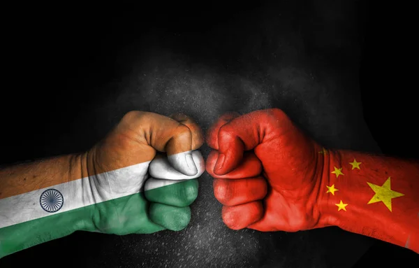 Hindistan ve Çin arasındaki çatışma ve gerginlik, bayraklı erkek yumrukları siyah arka planda izole edilmiş deri - iki ülke arasındaki kavga ve çatışma kavramı