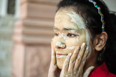 Genç esmer kız mesajı. Yüzüne doğal işitsel kozmetik maske takılmış. multani mitti / dolu toprak kil kopyalama alanı