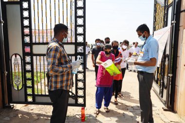 Jodhpur, Rajasthan, Hindistan, 13 Eylül 2020: Öğrenciler muayene merkezine girmeden önce hijyen sürecinden geçiyor, üniversite veya okul personeli tarafından covid-19 nedeniyle alınan güvenlik tedbirleri