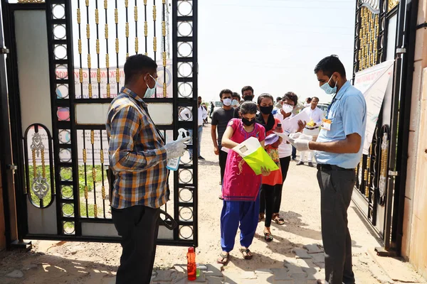 Jodhpur, Rajasthan, Hindistan, 13 Eylül 2020: Öğrenciler muayene merkezine girmeden önce hijyen sürecinden geçiyor, üniversite veya okul personeli tarafından covid-19 nedeniyle alınan güvenlik tedbirleri