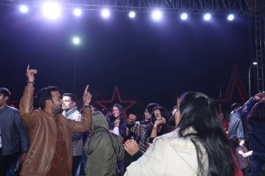 Kalabalık bir dans pistinde dans eden bir grup neşeli insan, bir törende ya da bir etkinlikte, dışarıda dans pistinde eğlenen bir grup insan.