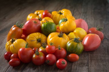 Rustik ahşap arka planda renkli domatesler.