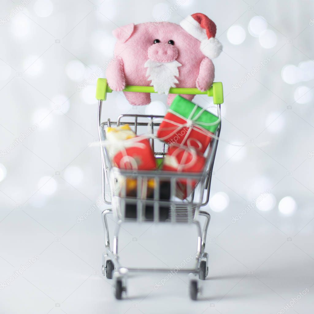 Christmas shopping. Pig with cart and gifts on a white background