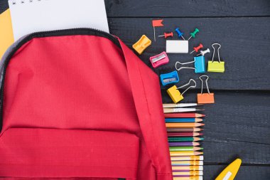 Eğitim için kırmızı çanta Siyah ahşap arka planda çocuklar okul konseptine geri dönün