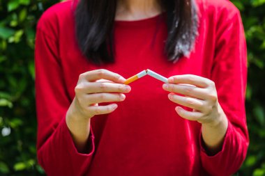 31 Mayıs Dünya Tütün Yasağı Günü, Asyalı sigara içen kadın sigarayı bırakmak ya da sigarayı bırakmak için ellerini kullanıyor.