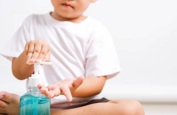 Nahaufnahme Asiatischer Kleiner Junge Sitzt Beim Auftragen Von Fläschchenpumpenspender Desinfektionsmittel — Stockfoto