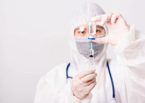 亚洲女医生或穿着Ppe制服的护士 戴着防护面罩的手套在实验室里拿着针头注射器药物和药瓶疫苗瓶 健康医学概念 — 图库照片