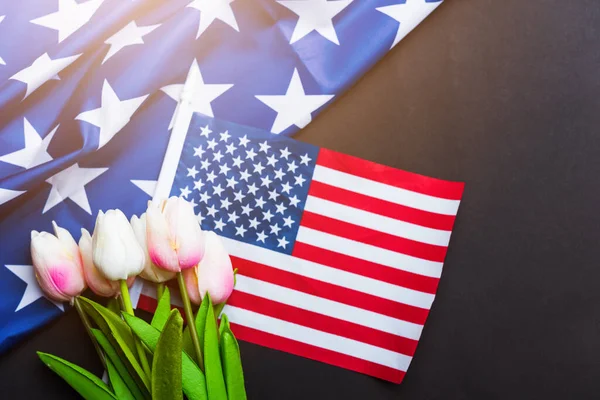 Happy Memorial Day Remember previously but now seldom called Decoration Day, American flag and a Tulip flower on a black background and copy space, a federal holiday in the United States