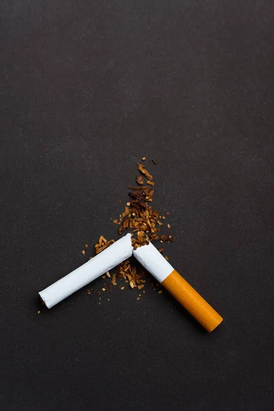 31 May of World No Tobacco Day, no smoking, close up of broken pile cigarette or tobacco STOP symbolic on black background with copy space, and Warning lung health concept