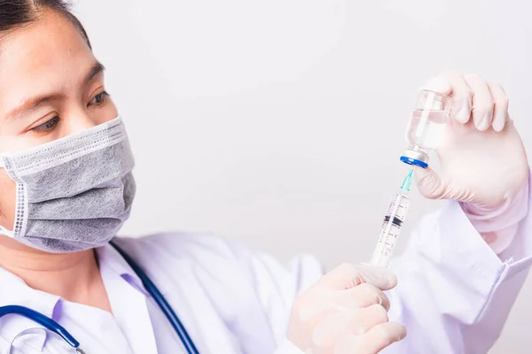 閉鎖女性医師 看護師や研究室での均一な着用フェイスマスク保護で科学者バイアルワクチンボトルに注射器を保持し 注射器 医学発生コロナウイルスCovid 19の概念 ロイヤリティフリーのストック画像