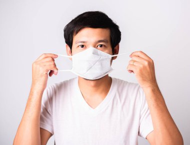 Coronavirus 'a karşı cerrahi hijyenik koruyucu yüz maskesi takan Asyalı yakışıklı adam, izole edilmiş beyaz arka plan, COVID-19 tıbbi konsept.