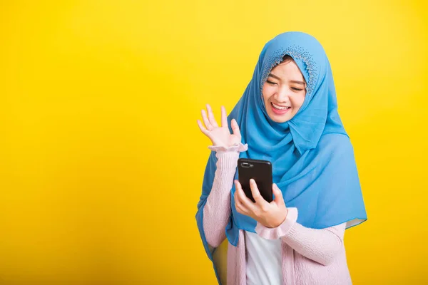 アジア系ムスリムアラブ人 幸せな美しい若い女性の肖像 イスラームという宗教的な摩耗ベールヒジャーブ面白い笑顔彼女は自画やビデオ通話の携帯電話を上げる手と言うこんにちは黄色の背景に孤立 — ストック写真