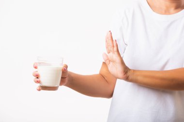 Kapalı tabela tutan kadın elini kaldırıyor cam süt tutan el kullanıyor kötü mide ağrısı laktoza duyarlı sağlıksız süt ürünleri, beyaz arka planda izole edilmiş stüdyo çekimi