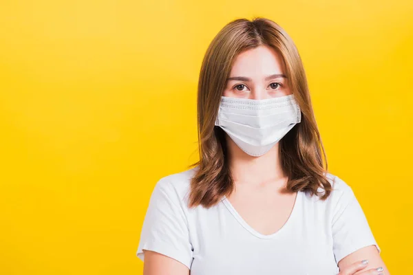 肖像画アジアの美しい若い女性は コピースペースと 黄色の背景に顔マスク保護フィルターほこりPm2 5公害 抗スモッグ 大気汚染やCovidウイルスを身に着けている腕を渡りスタンド — ストック写真