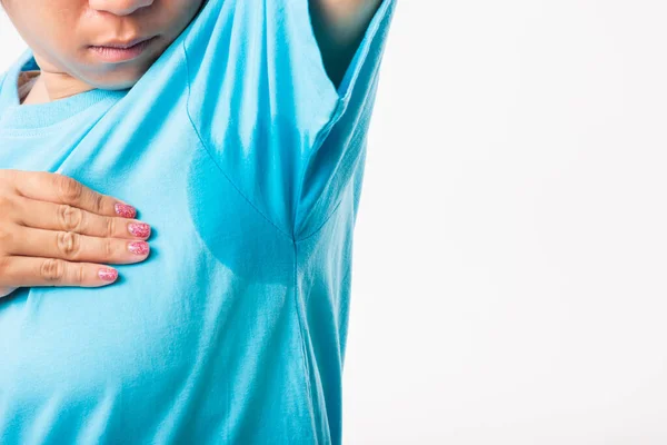 Closeup young Asian young woman hyperhidrosis sweating. Female very badly have armpit sweat stain on her clothes, studio shot isolated on white background, Healthcare medical concept