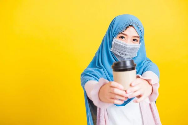 アジアのイスラム教徒のアラブ人 幸せな美しい若い女性の肖像イスラム教の宗教的な摩耗ベールヒジャーブと顔のマスクは 彼女が隔離された黄色の背景をコーヒーカップを保持病気のコロナウイルスを隔離保護します — ストック写真