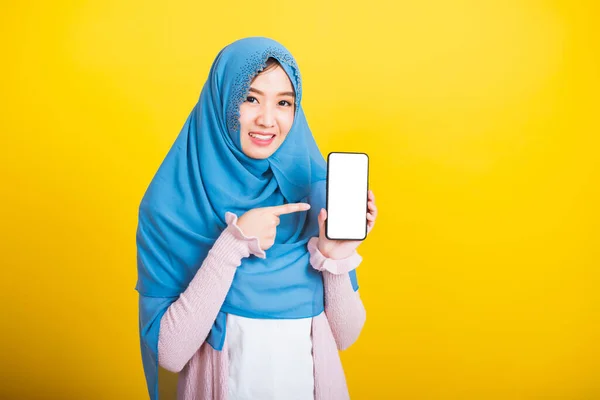 アジア系ムスリムアラブ人 幸せな美しい若い女性の肖像イスラム教の宗教的な摩耗ベールヒジャーブ面白い笑顔彼女は空白の画面を示していますスマート携帯電話と黄色の背景に隔離されたポイント画面 — ストック写真