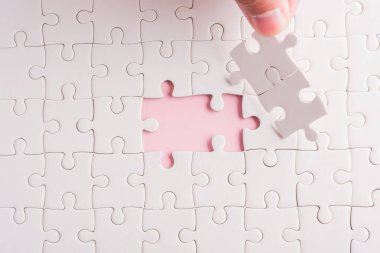 Üst görünüm düz konum son parça beyaz kağıt yapboz oyunu çözülmesi için yerleştirilen son parçalar tam görev, pembe arka plan üzerine stüdyo çekimi, quiz hesaplama konsepti