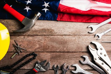 ABD İşçi Bayramı konsepti, ahşap masa üzerinde Amerikan bayrağı olan çeşitli İngiliz anahtarı. Eylül 'ün ilk pazartesi günü, işçi hareketinin kurulması ve Amerikan işçilerinin sosyal hizmetlerine adanması.