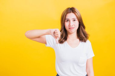 Asyalı güzel bir kadının portresi. Mutsuz, negatif bir jest. Parmak işareti gösterme ya da beğenmeme.