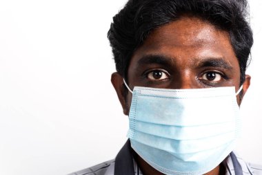 Asyalı mutlu portre genç siyah adam yüz maskesi takıyor virüs koronavirüs salgınından ya da hava kirliliği görünümlü kamera, stüdyo görüntüsü beyaz arka planda izole, COVID-19 kavramını durdurun 