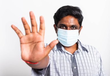 Koronavirüse karşı cerrahi hijyenik koruyucu yüz maskesi takan yakışıklı Asyalı yakışıklı bir adam ve el işaretini yükselten stüdyo resmi, izole edilmiş beyaz arka plan, COVID-19 tıbbi konsept.