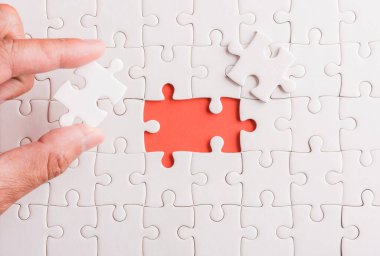 Üst görünüm düz konum son parça beyaz kağıt yapboz oyunu çözülmesi için yerleştirilen son parçalar tam görev, pembe arka plan üzerine stüdyo çekimi, quiz hesaplama konsepti