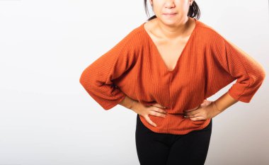 Hastalandığı Asyalı kadının karın ağrısı var. Karın ağrısı, karın ağrısı, karın ağrısı, şişkinlik ya da kronik mide iltihabı, beyaz arka planda izole edilmiş stüdyo çekimi.