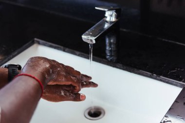 Siyah adamın ellerini yıkamak lavaboya sabun ve suyla ovmak salgın koronavirüsünün virüs yaymasını önlemek için, COVID-19 konseptini karantina temizliği için hijyen.