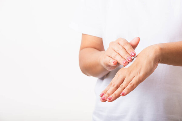 Крупный план молодая азиатская женщина нанесение лосьона косметический крем увлажнитель на нее за ладонью руки, студия выстрел изолированы на белом фоне, Здравоохранение медицинской и гигиены кожи уход за телом