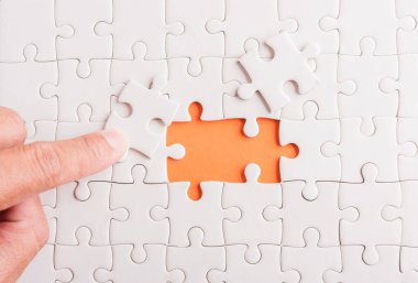 Top view düz konum son parça beyaz kağıt yapboz oyunu çözülmesi için yerleştirilen son parçalar tam görev, turuncu arka plan üzerine stüdyo çekimi, sınav hesaplama konsepti