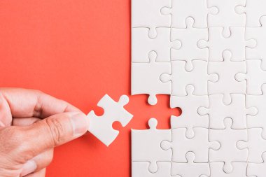 Üst görünüm düz konum son parça beyaz kağıt yapboz oyunu çözülmesi için yerleştirilen son parçalar tam görev, pembe arka plan üzerine stüdyo çekimi, quiz hesaplama konsepti