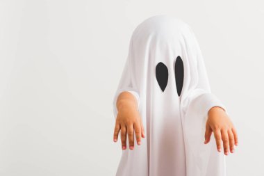 Komik cadılar bayramı çocuğu kavramı, beyaz kostümlü şirin çocuk cadılar bayramı hayaleti korkunç, stüdyo resmi beyaz arka planda izole edilmiş.