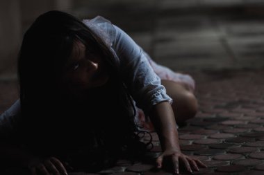 Kanlı kız zombi. Kanlı Asyalı kadın hayalet. Karanlık evdeki korkunç korku tüyler ürpertici sürünme yavaş yavaş yayılıyor. Saç kaplaması kameraya bakıyor, Cadılar Bayramı festivali konsepti.