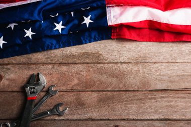 ABD İşçi Bayramı konsepti, ahşap masa üzerinde Amerikan bayrağı olan çeşitli İngiliz anahtarı. Eylül 'ün ilk pazartesi günü, işçi hareketinin kurulması ve Amerikan işçilerinin sosyal hizmetlerine adanması.