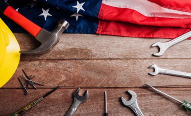 ABD İşçi Bayramı konsepti, ahşap masa üzerinde Amerikan bayrağı olan çeşitli İngiliz anahtarı. Eylül 'ün ilk pazartesi günü, işçi hareketinin kurulması ve Amerikan işçilerinin sosyal hizmetlerine adanması.