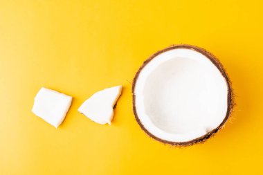 Mutlu hindistan cevizi günü konsepti, taze hindistan cevizi grubu farklı yarılar ve dilimler, sarı arka planda izole edilmiş stüdyo çekimi