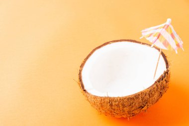 Mutlu hindistan cevizi günü konsepti, taze hindistan cevizi ve güneş şemsiyesi, stüdyo çekimi turuncu arka planda, plaj tropikal meyve yaz tatili