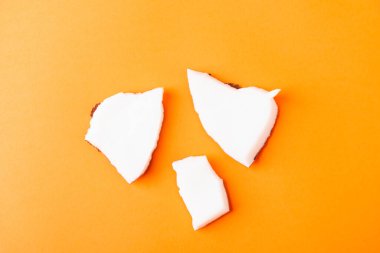 Mutlu hindistan cevizi günü konsepti, taze hindistan cevizi grubu parçaları, turuncu arka planda izole edilmiş stüdyo fotoğrafları.