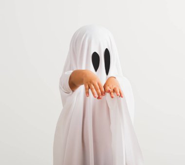 Komik cadılar bayramı çocuğu kavramı, beyaz kostümlü şirin çocuk cadılar bayramı hayaleti korkunç, stüdyo resmi beyaz arka planda izole edilmiş.