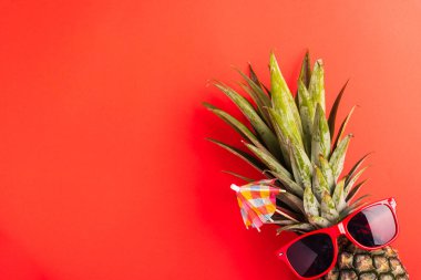 Yaz Ananas Günü Konsepti 'ni kutlayın, Top view düz çizgi ananas yatağı kırmızı güneş gözlüğü takın, stüdyo resmi kırmızı arka planda, tatil yazı tropikal, minimal stil meyveli.