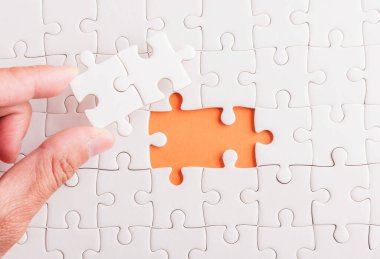 Top view düz konum son parça beyaz kağıt yapboz oyunu çözülmesi için yerleştirilen son parçalar tam görev, turuncu arka plan üzerine stüdyo çekimi, sınav hesaplama konsepti