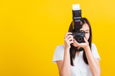 Mutlu Asyalı genç kadın fotoğrafçı gülümsemesinin portresi. Fotoğraf çek ve geçmişe dönük dijital aynasız fotoğraf makinesine bak. Çekime hazır.